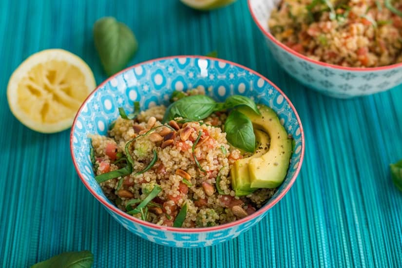 bowl of quinoa salad on a blue backdrop