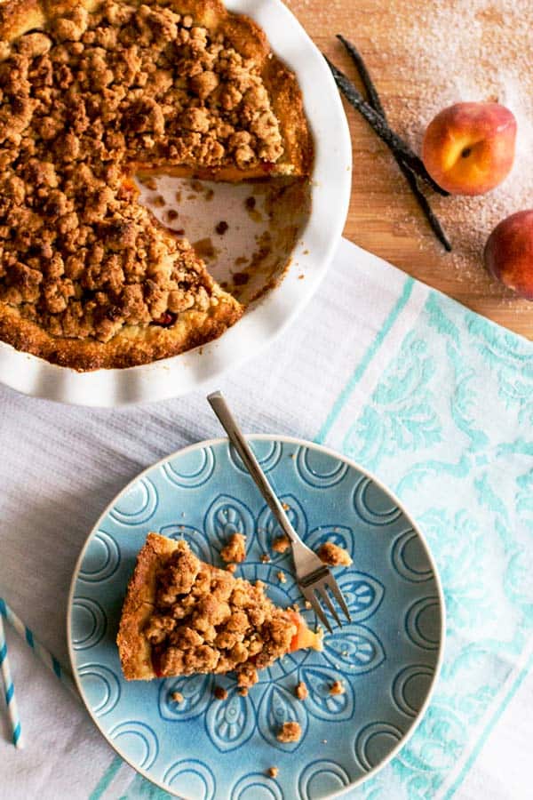 top down view on plate with peach pie slice, next to a white pie plate