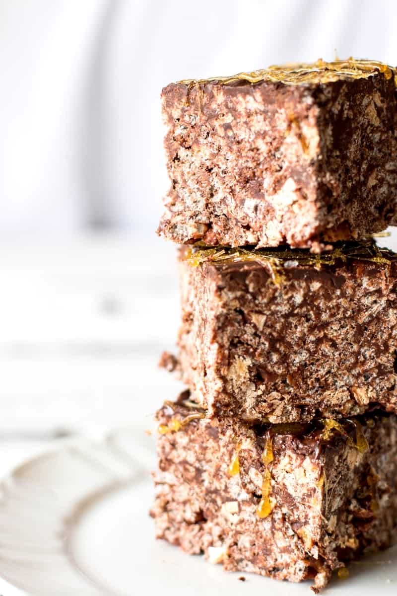 stack of three Rice Krispie treats with chocolate on a white plate