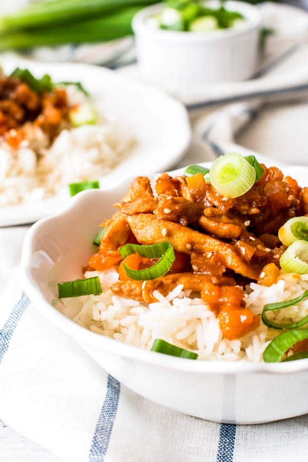 close up photo of apricot chicken in a bowl with rice
