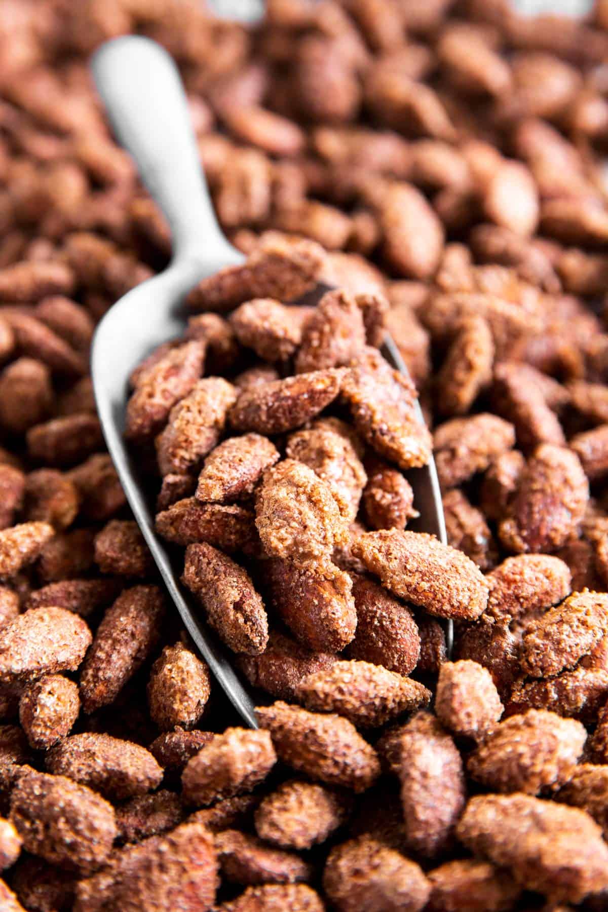 close up of candied almonds on sheet pan with spoon