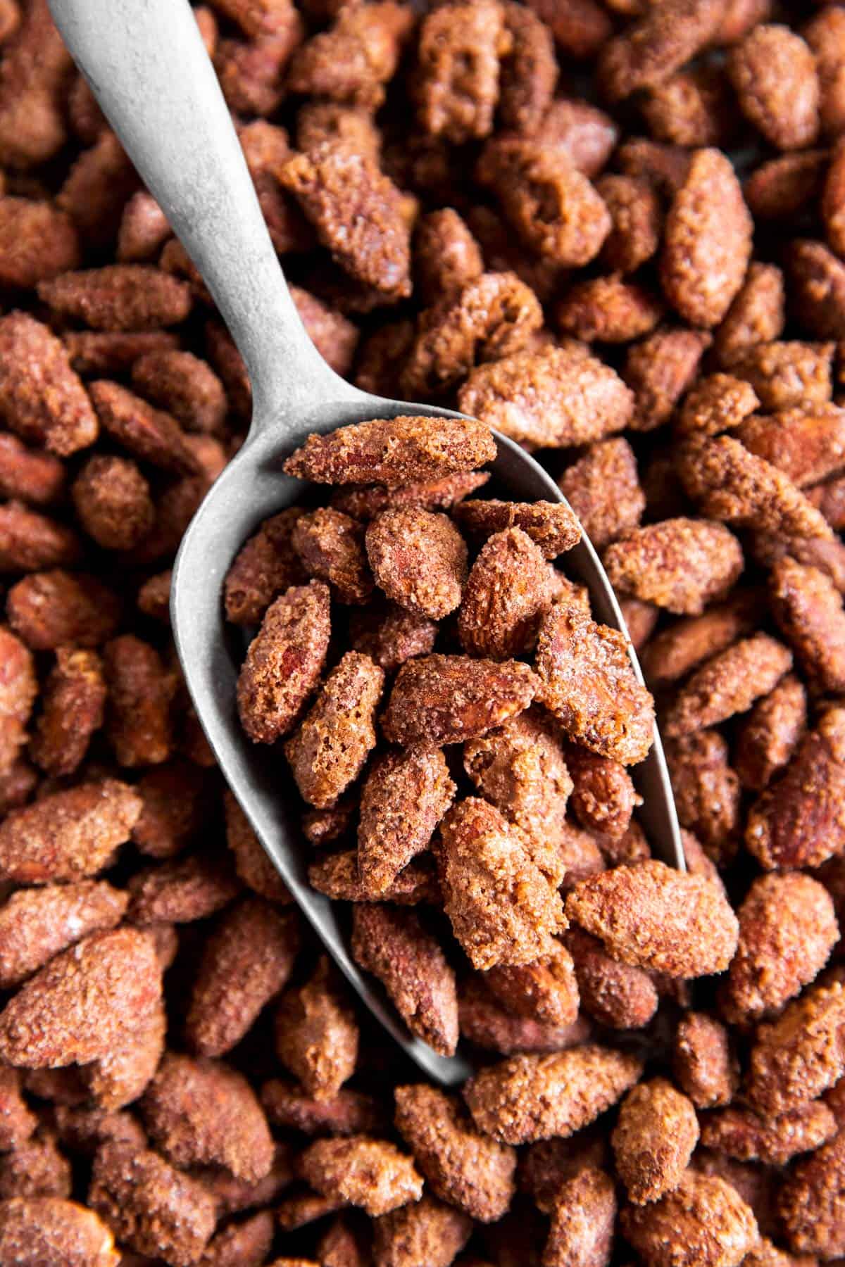 overhead view of small metal shovel in pan with candied almonds