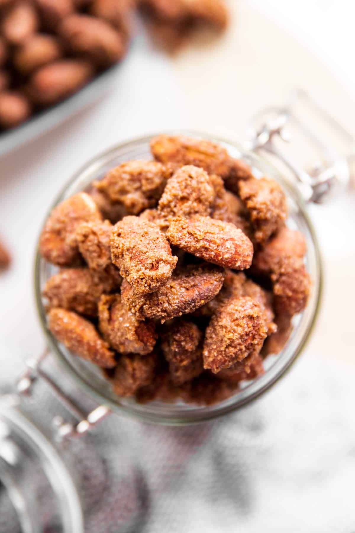 overhead closeup of candied almonds in a glass jar