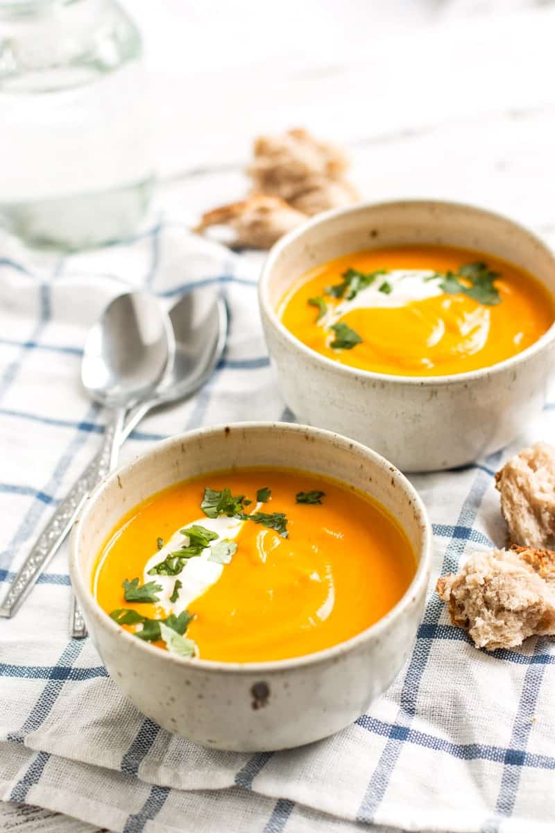 frontal view of two bowls with carrot soup