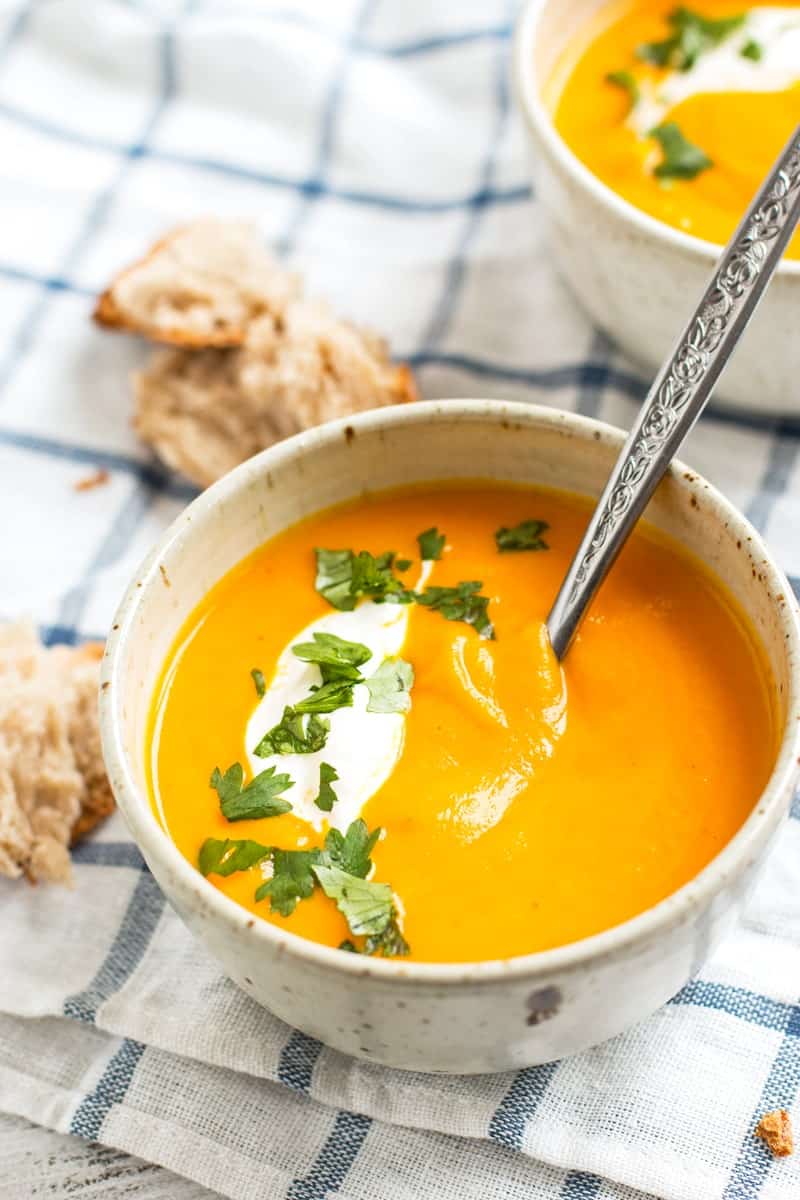 frontal view of white bowl with carrot soup