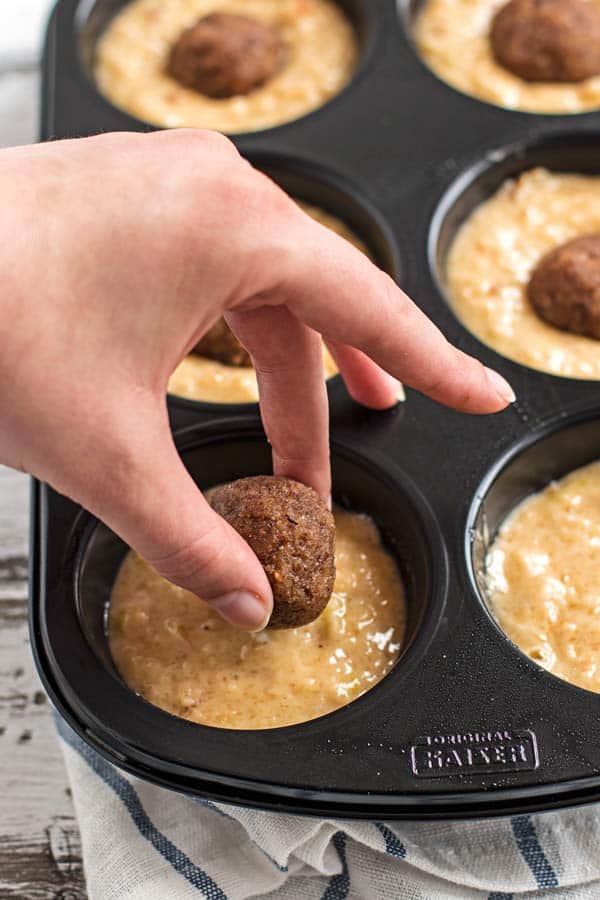 Adding cinnamon filling to apple muffins.