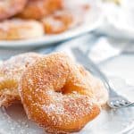 old fashioned apple fritters on a white plate with a fork