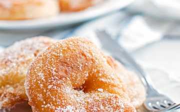 old fashioned apple fritters on a white plate with a fork