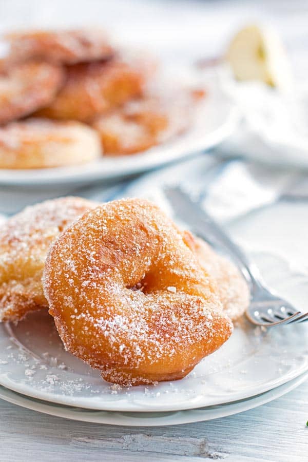 old fashioned apple fritters on a white plate with a fork