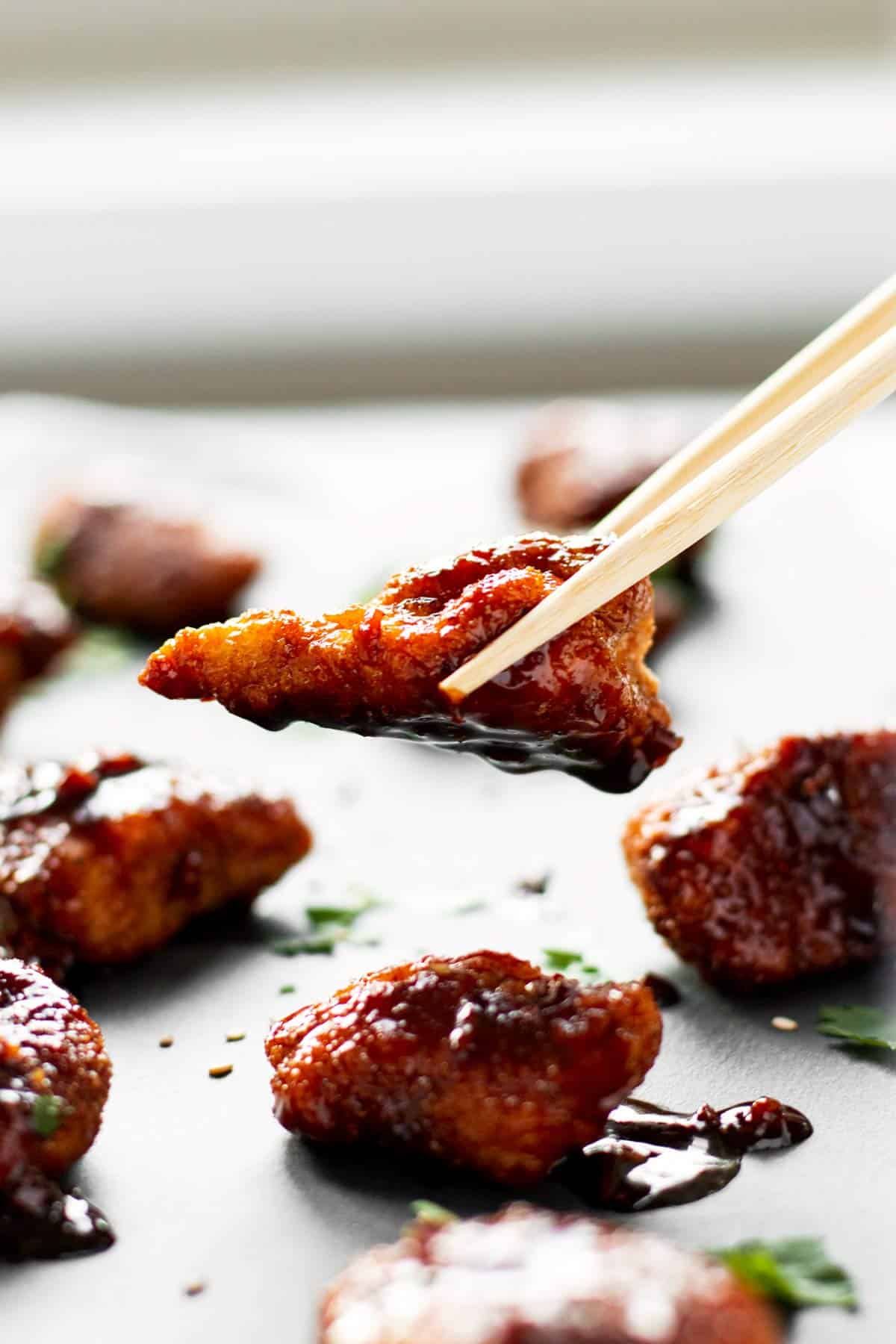 chopsticks holding piece of crispy garlic chicken