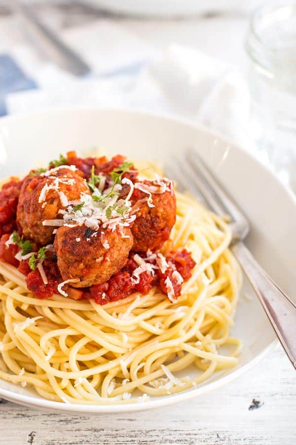 white plate with spaghetti and turkey meatballs in tomato sauce