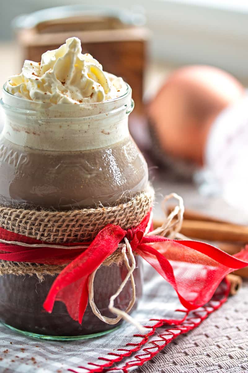 frontal view on glass cup with gingerbread hot chocolate on festive table setting