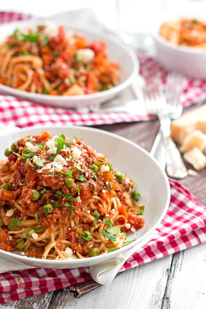 frontal view on two white plates filled with spaghetti and spaghetti sauce