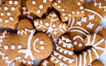 pile of gingerbread men and gingerbread cookie shapes decorated with icing