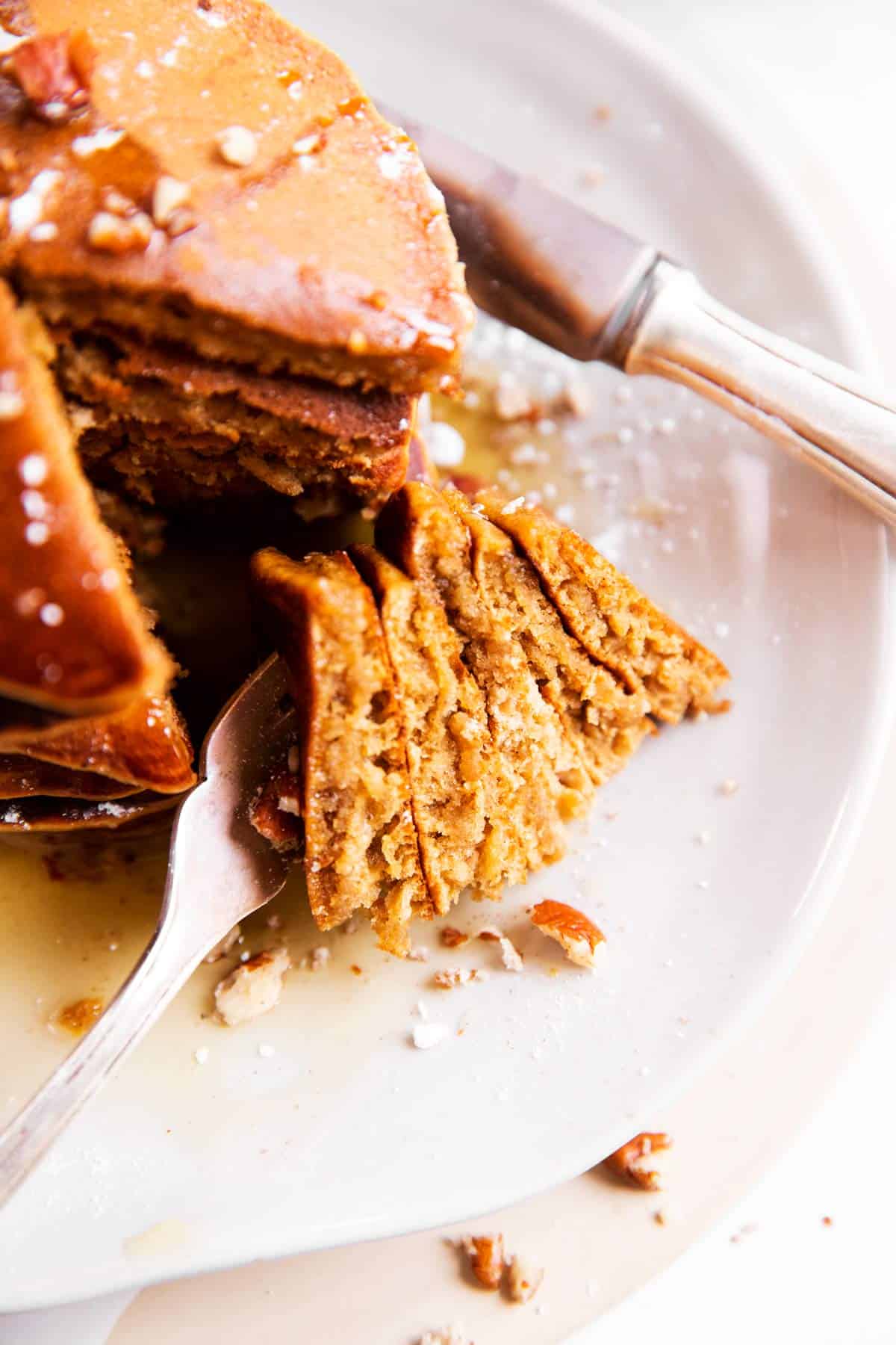 close up of cut up gingerbread pancakes on a white plate