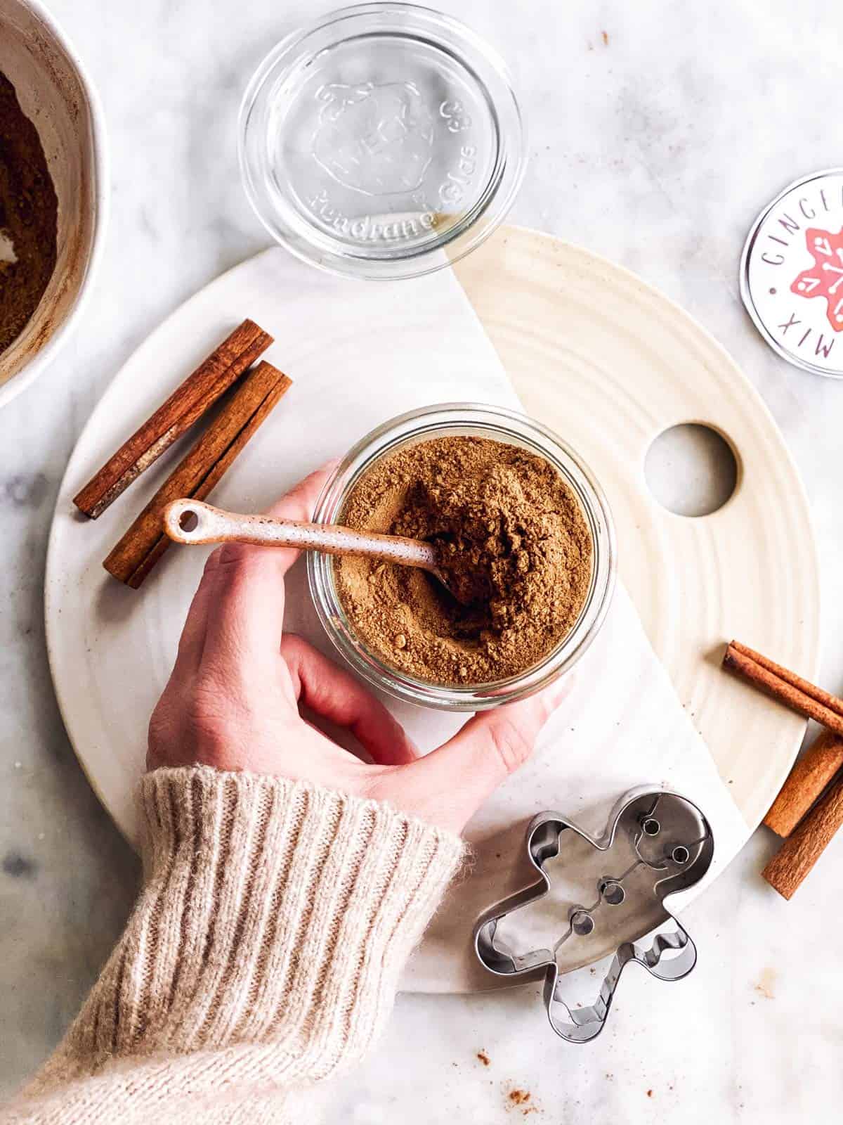 female hand holding jar with gingerbread spice mix