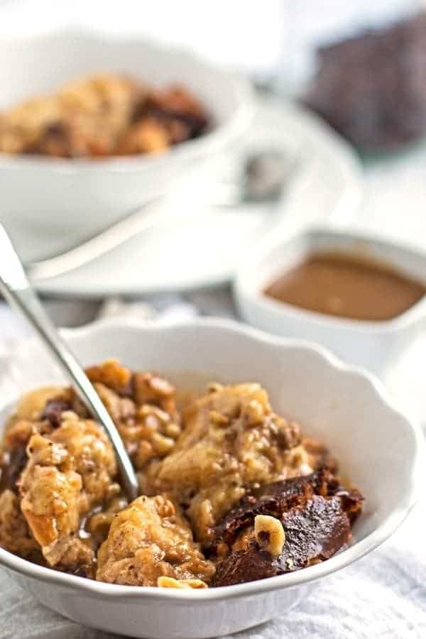 close up photo of a white bowl with bread pudding