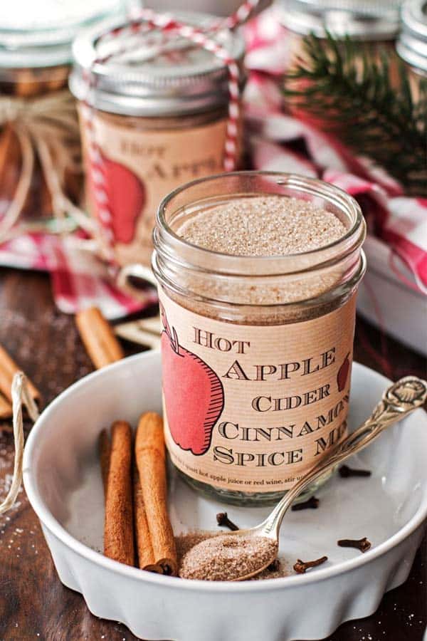 open jar with apple cider spice mix on a Christmas decorated table