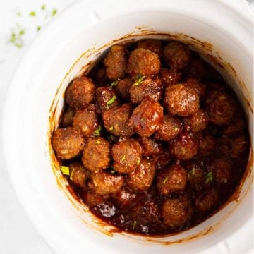 close up of white slow cooker with bbq meatballs