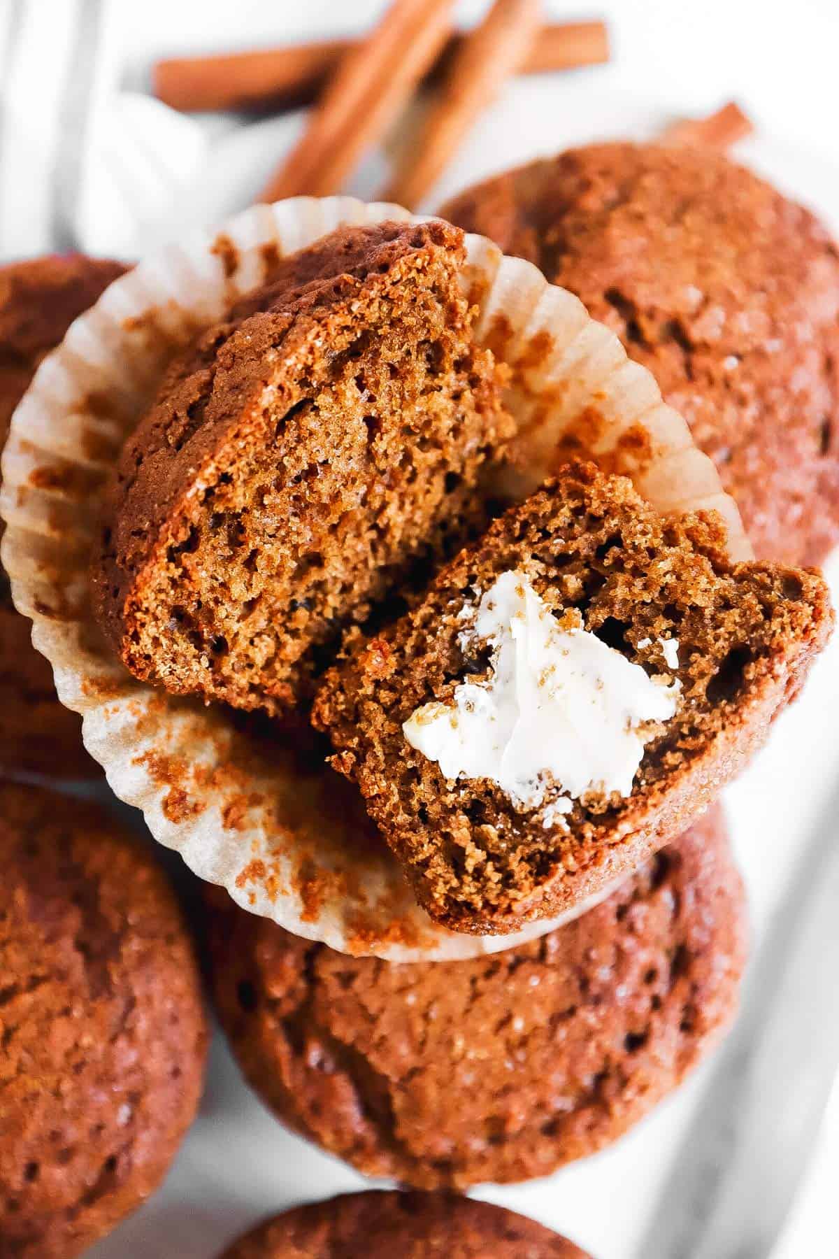 overhead view of sliced open gingerbread muffin smeared with butter