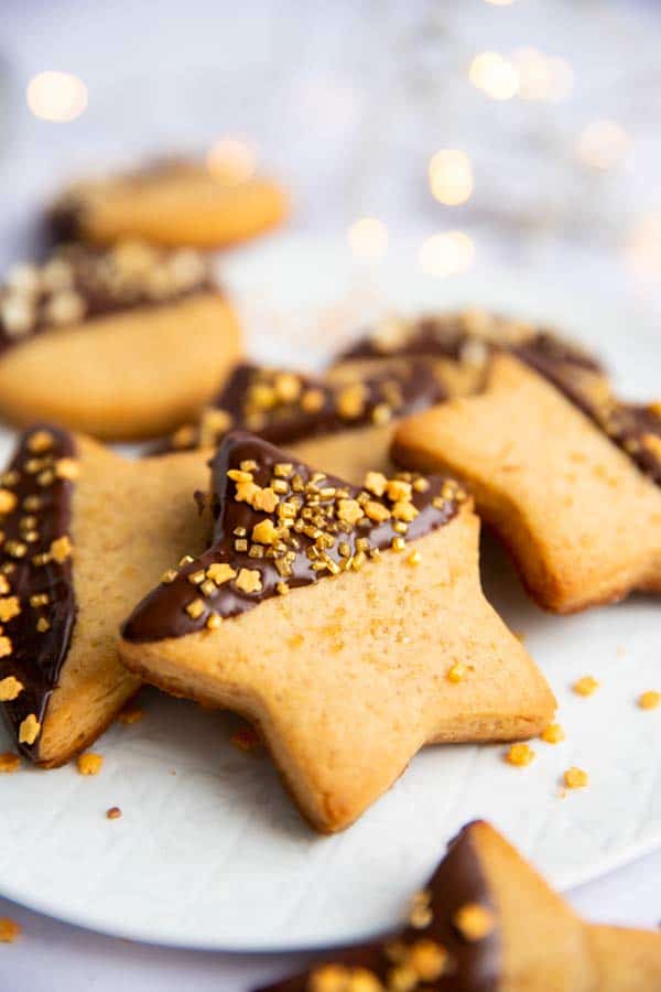 peanut butter shortbread cookie stars on a plate with chocolate glaze