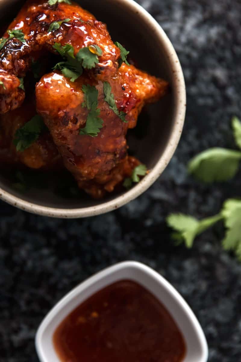 top down view on bowl with wings and small bowl of chili sauce