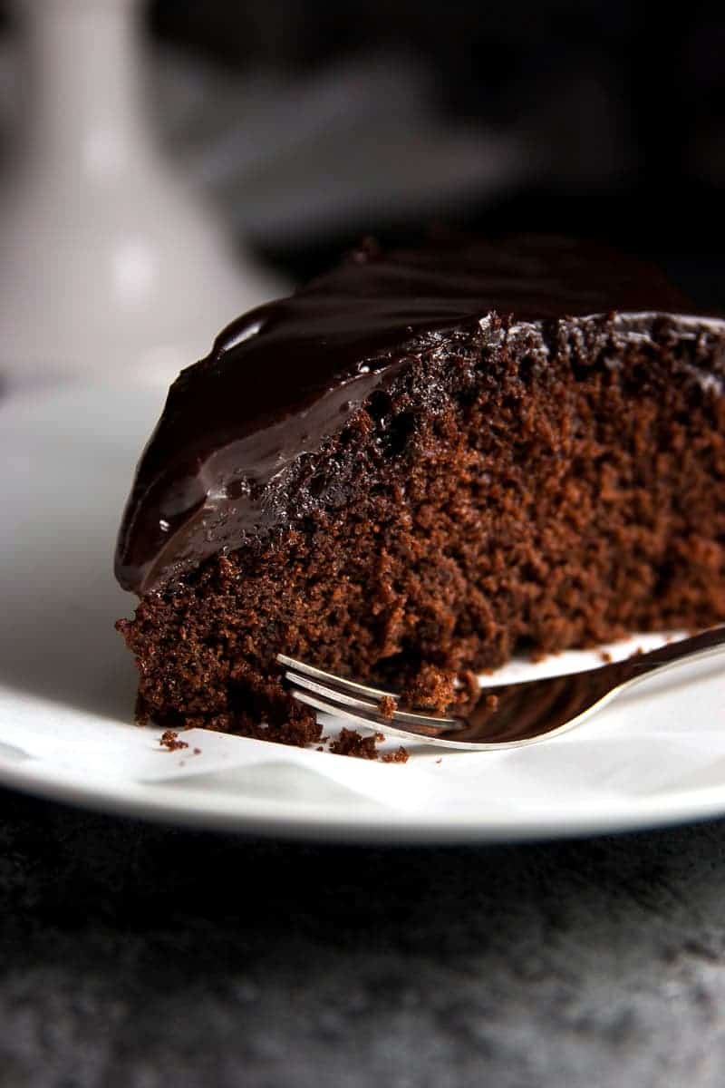 close up photo of chocolate honey cake on white plate