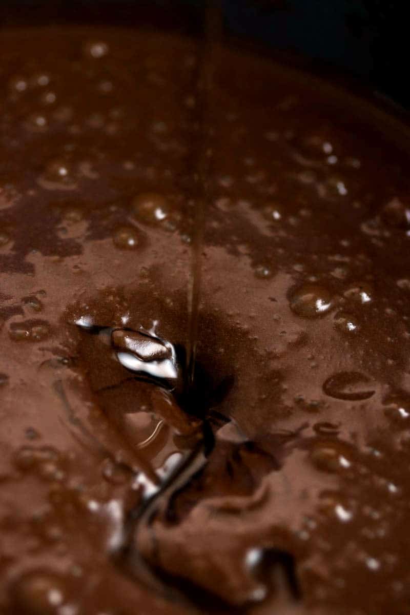 close up photo of honey drizzling into cake batter