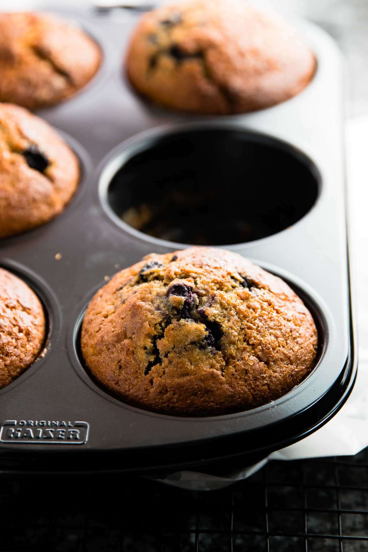 frontal view on muffin pan with baked lemon blueberry muffins