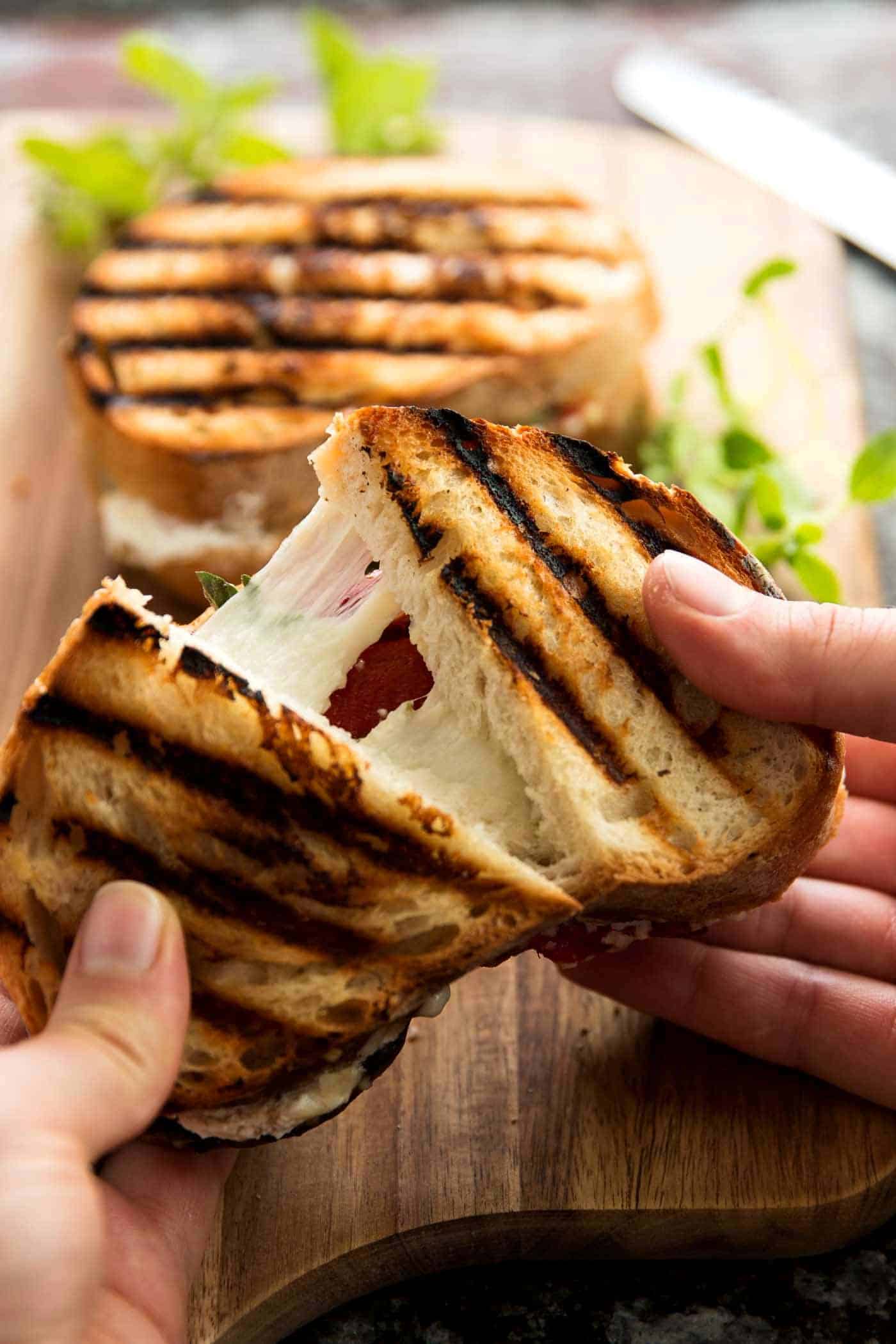 female hands pulling apart a grilled cheese sandwich