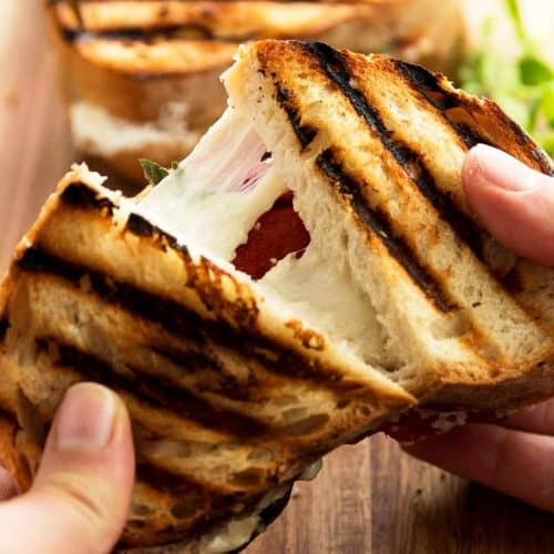 female hands pulling apart a grilled cheese sandwich