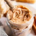 glass jar filled with honey butter in front of bread slices