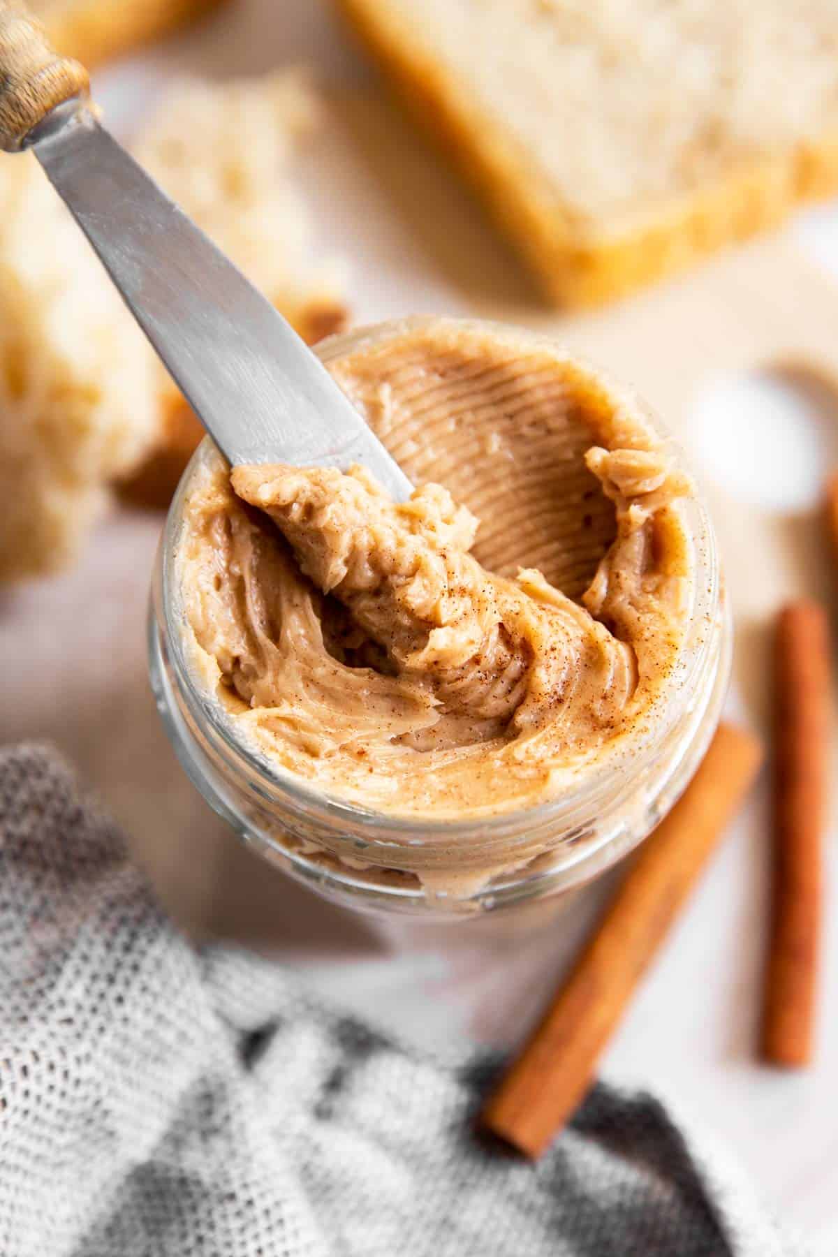 overhead view of knife stuck in jar with honey butter