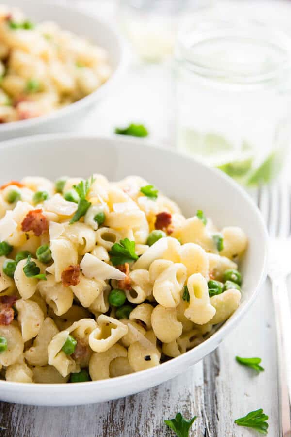 white plate with pea and bacon pasta