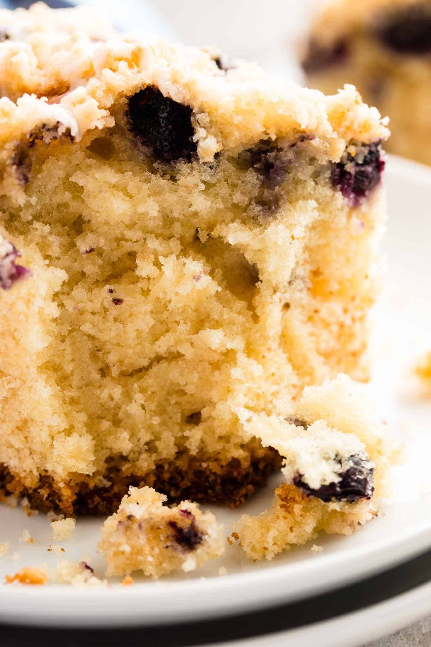 close up photo of a slice of lemon blueberry coffee cake with a bite taken out