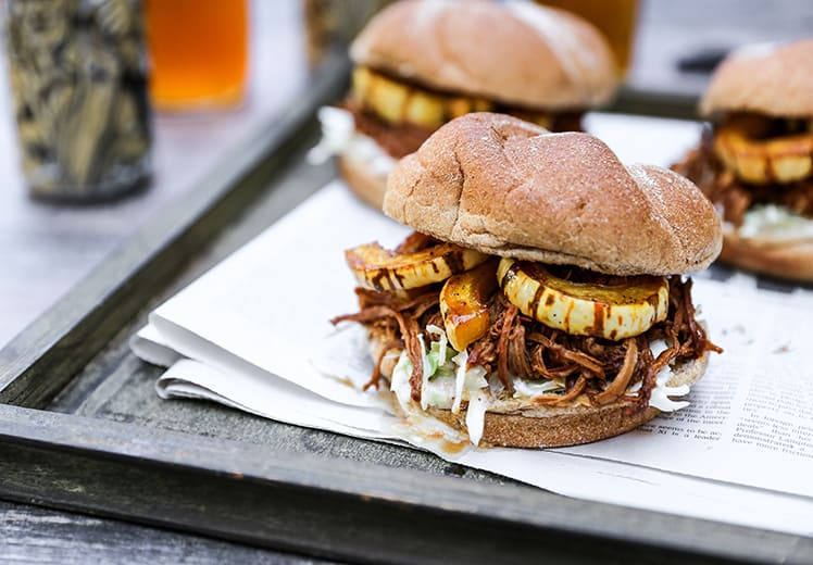 shredded pork sandwich on wooden tray