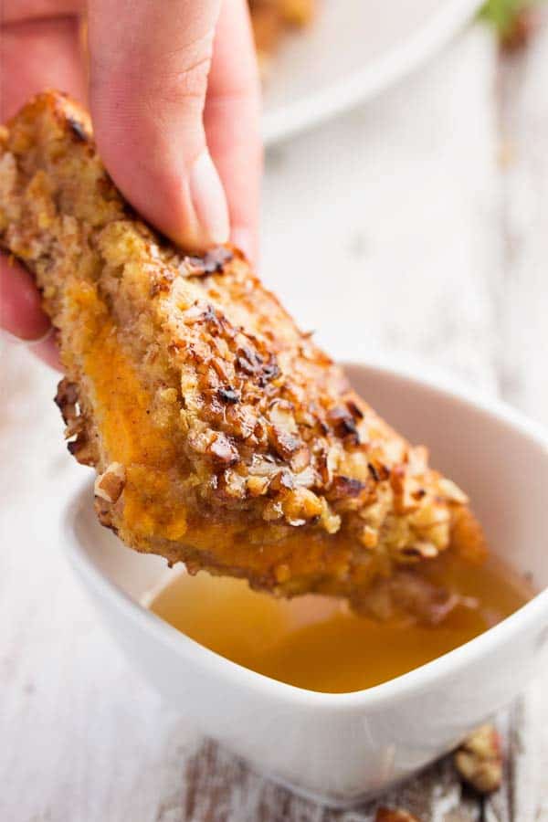 dipping pumpkin French toast in maple syrup