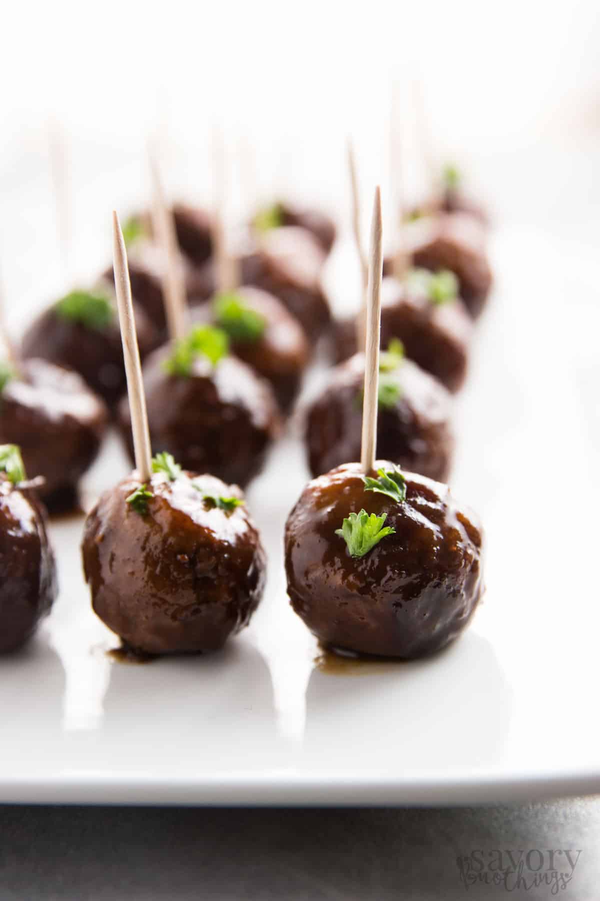 cranberry turkey meatballs on white platters with toothpicks