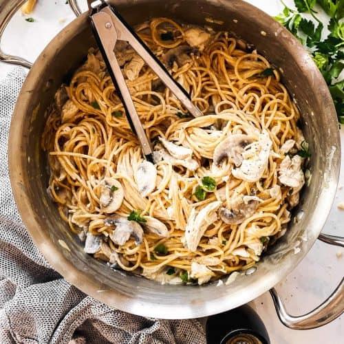 skillet with turkey tetrazzini surrounded by parmesan and parsley