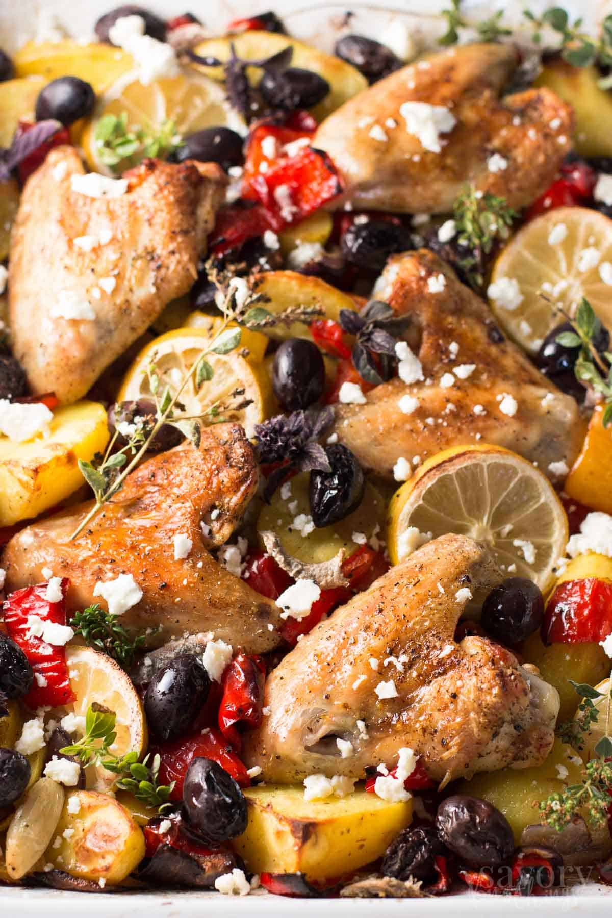 close up photo of greek chicken casserole with lemon slices and olives