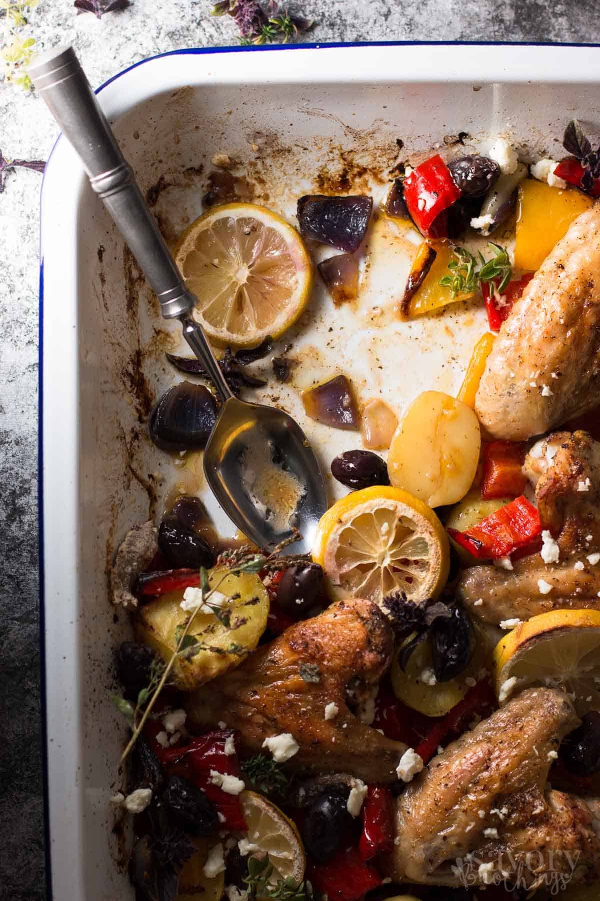 top down view on enamel dish with spoon and rest of greek chicken