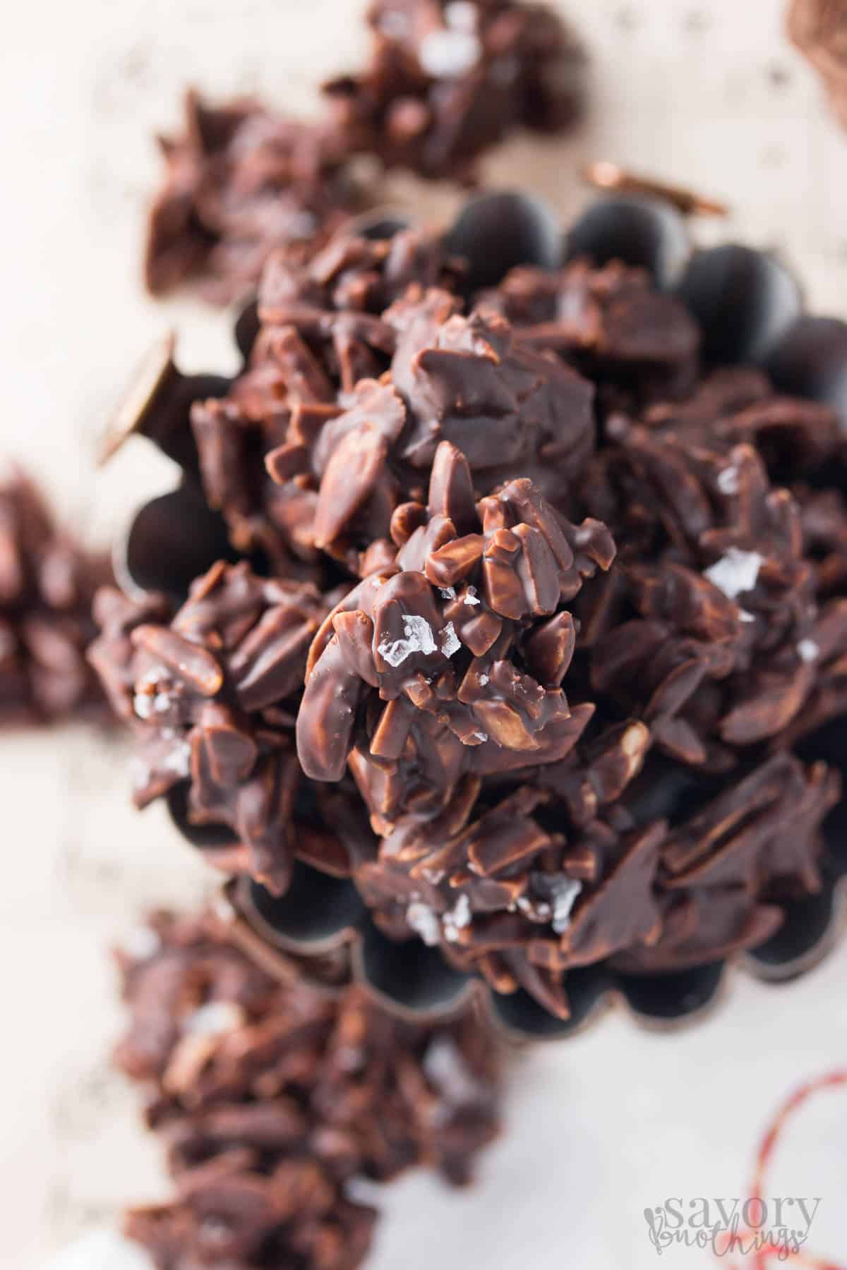 top down close up of dark chocolate and orange covered almonds with sea salt
