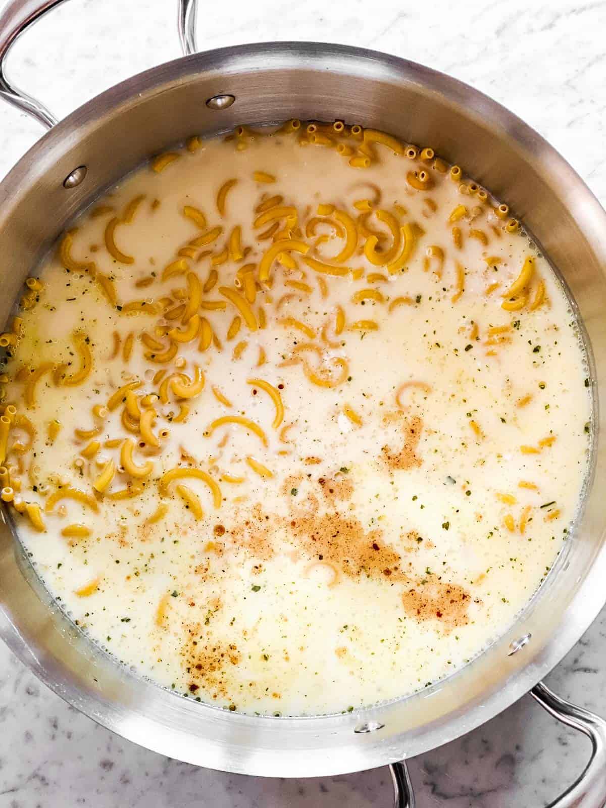 dry macaroni and milk in pot