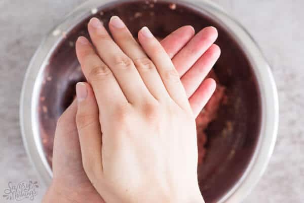 female hands rolling a meatball
