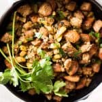 top down view on female hands holding black skillet with apple stuffing