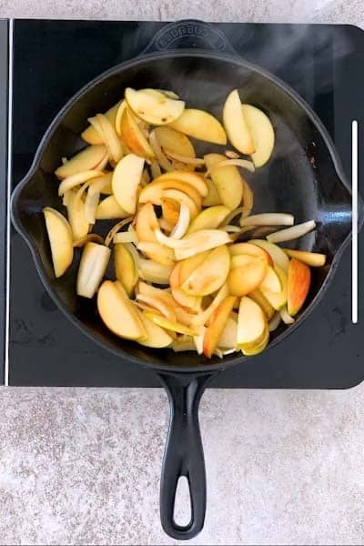 Cooked apples and onions in a cast iron skillet