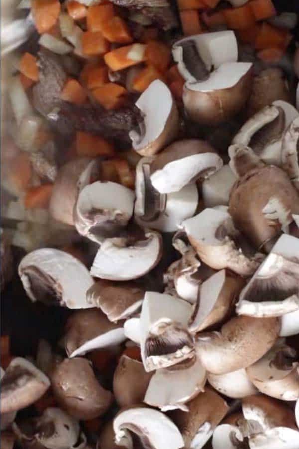 raw sliced mushrooms in a skillet