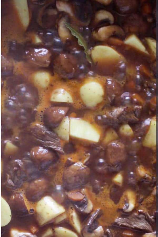 beef tips, gravy and vegetables simmering in a skillet