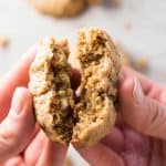 female hand breaking apart an oatmeal cookie