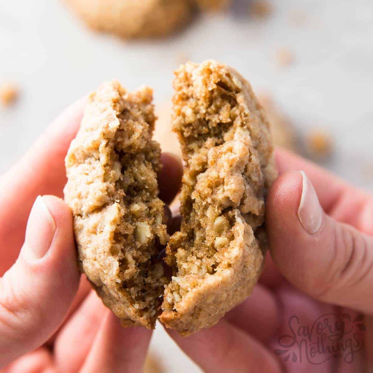 hands holding cracked oatmeal cookie